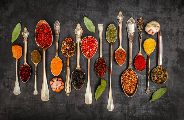 Различные ложки специй на каменном столе. Вид сверху
 .