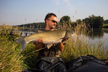 Sazan balıkçılık kupa ile mutlu fener. Amur (çim sazan). Balık tro