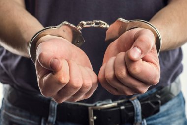Yetişkin erkek tutuklandı ve kelepçeli. Tutuklu adam. El ile 