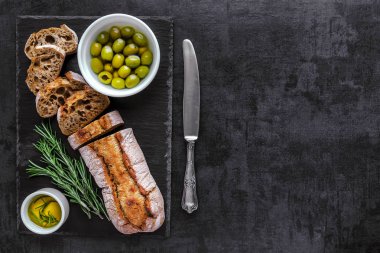 Otlar ve zeytin, üst v ile siyah arduvaz gemide ciabatta ekmeği