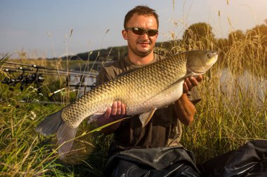 Sazan balıkçılık kupa ile mutlu fener. Amur (çim sazan). Balık tro