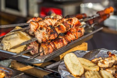 Kömürlerde barbekü kızartması. Bulanık insanlar masada yemek 