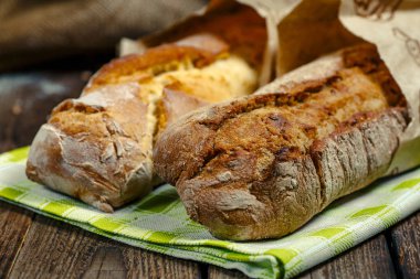 R ahşap kesme tahtası üzerinde dilimlenmiş taze pişmiş ciabatta ekmek