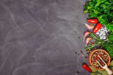 Siyah taş masada taze otlar ve baharatlar. Yemek konsepti. Fre