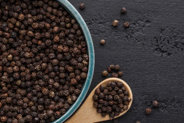 Peppercorn background. Dry black pepper seeds. Top view.On a black background. free space for your text.