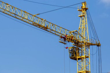 Şantiye arka planı. Vinçler ve yeni çok katlı binalar kaldırma. I.ndustrial arka plan. Mavi gökyüzüne karşı şantiye çalışmaları