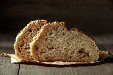 Ekmek, kırsal ahşap arka planda dilimlenmiş geleneksel ekşi ekmek. Geleneksel mayalanmış ekmek pişirme yöntemleri kavramı. Sağlıklı yemek..