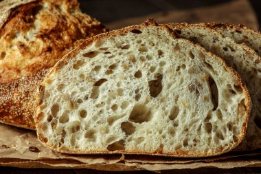 Ekmek, kırsal ahşap arka planda dilimlenmiş geleneksel ekşi ekmek. Geleneksel mayalanmış ekmek pişirme yöntemleri kavramı. Sağlıklı yemek..