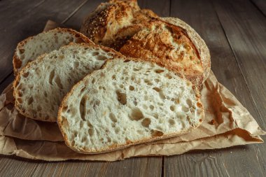 Ekmek, kırsal ahşap arka planda dilimlenmiş geleneksel ekşi ekmek. Geleneksel mayalanmış ekmek pişirme yöntemleri kavramı. Sağlıklı yemek..