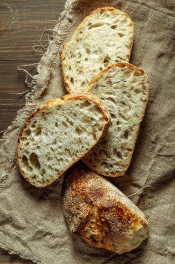 Ekmek, kırsal ahşap arka planda dilimlenmiş geleneksel ekşi ekmek. Geleneksel mayalanmış ekmek pişirme yöntemleri kavramı. Sağlıklı yemek..