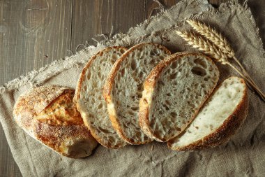 Ekmek, kırsal ahşap arka planda dilimlenmiş geleneksel ekşi ekmek. Geleneksel mayalanmış ekmek pişirme yöntemleri kavramı. Sağlıklı yemek..