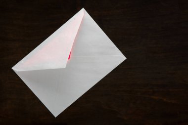 Sevgililer günü kartı posta zarf içinden koyu ahşap arka plan üzerinde kırmızı bir parıltı ile