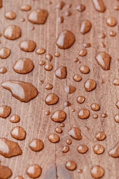 Su bir kahverengi ahşap yüzeye bırakır. Seçici odak