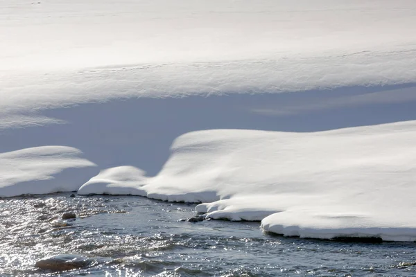 Mountains, snow, river. Close-up of a snow-covered bank of a mou — Stock Photo, Image