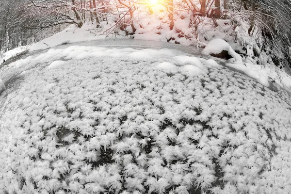 バラのような雪と氷の結晶から川の氷の幻想的な花の山 水と穏やかな夜の照明の厳しい霜を描画します — ストック写真