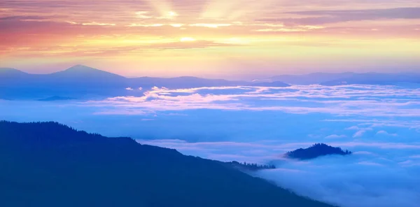 Nuvens nebulosas nas montanhas ao nascer do sol — Fotografia de Stock