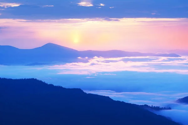 Nuvens nebulosas nas montanhas ao nascer do sol — Fotografia de Stock