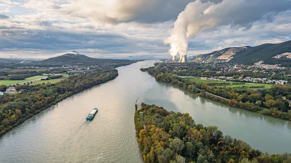 Saulce, Fransa - 30 Ekim 2024: Rhone Nehri 'nin Cruas nükleer enerji santrali ile yeşil vadiden geçen insansız hava aracı görüntüsü buhar yayıyor
