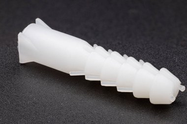 Koyu, desenli bir arka planda beyaz plastik bir duvarın yan açısı.