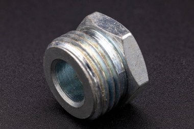 Mühendisliği ve sanayiyi temsil eden harici ipliklerle parlak bir metal cıvatanın yakın çekimi