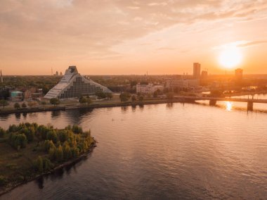 Renkli bir gün batımında yepyeni Letonya Milli Kütüphane. Havadan görünümü yukarıdaki. Pinacle modern mimarinin şu Daugava Nehri yanında yer alan.