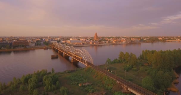 ダウガヴァ川とそれ以上の橋でリガの旧市街の美しい眺め 日没時にパノラマのリガ シーン — ストック動画