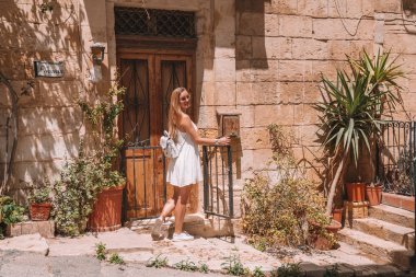 Malta Island Valletta ve Marsaxlokk köyü yakınındaki keşfetmek beyaz elbiseli güzel kız. 
