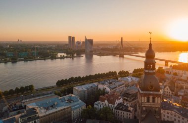 Old Riga kasaba Vecriga Letonya üzerinde gün batımının muhteşem havadan görünümü. Nehir Daugava, kubbeler Katedrali ve ön planda altın horoz ile. 