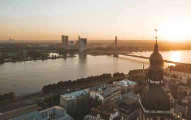 Old Riga kasaba Vecriga Letonya üzerinde gün batımının muhteşem havadan görünümü. Nehir Daugava, kubbeler Katedrali ve ön planda altın horoz ile. 