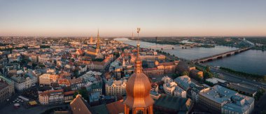 Old Riga kasaba Vecriga Letonya üzerinde gün batımının muhteşem havadan görünümü. Nehir Daugava, kubbeler Katedrali ve ön planda altın horoz ile. 