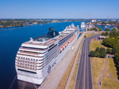 03 Haziran 2018. Riga, Letonya. Görünümü klasik Amerikan retro otomobil resmi geçit Riga, Letonya tarafından büyük Msc cruise Orkestrası. Vintage Cabrio araba boş sokakta sürüş.