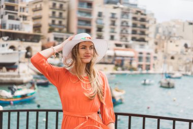 Valletta, Malta. 20 Mayıs 2018. Malta Adası üzerinde demirledi tekne tarafından yürüyüş kırmızı elbiseli güzel kız. 