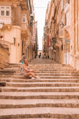 Valletta, Malta. 20 Mayıs 2018. Valletta dar sokaklarında merdivenlerden üzerinde oturan genç kız. 