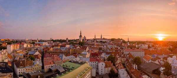 Beautiful orange sunset over old town of Tallinn in Estonia with the Raekoja plats, castle and old medieval towers.