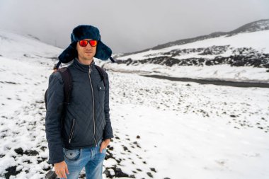 Genç adam kar ve sis Etna Yanardağı hiking.