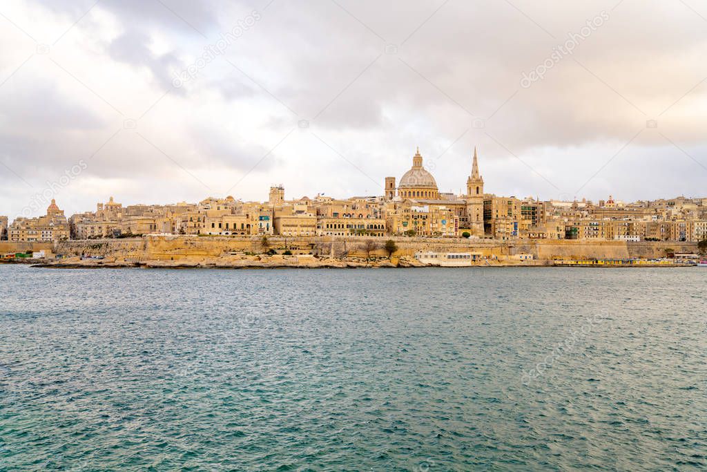 Panoramic view of Valletta Skyline at beautiful sunset from Sliema with churches of Our Lady of Mount Carmel and St. Paul's Anglican Pro-Cathedral, Valletta, Capital city of Malta.
