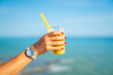 Sarı yüzlü cam okyanus arka planda tutan minik el