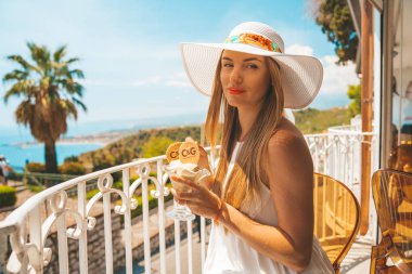 15 Mayıs 2018. Taormina, İtalya. Genç kız dondurma Akdeniz üzerinde inanılmaz bir manzaralı balkonda yemek