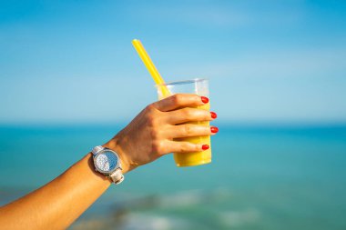 Sarı yüzlü cam okyanus arka planda tutan minik el