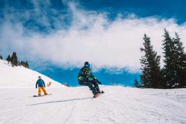 Genç adam Avusturya Alplerinde farklı hile yapma, snowboard