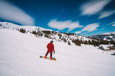 Genç adam Avusturya Alplerinde farklı hile yapma, snowboard