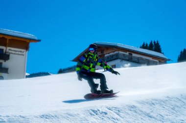 Genç adam Avusturya Alplerinde farklı hile yapma, snowboard