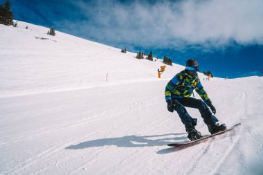 Genç adam Avusturya Alplerinde farklı hile yapma, snowboard