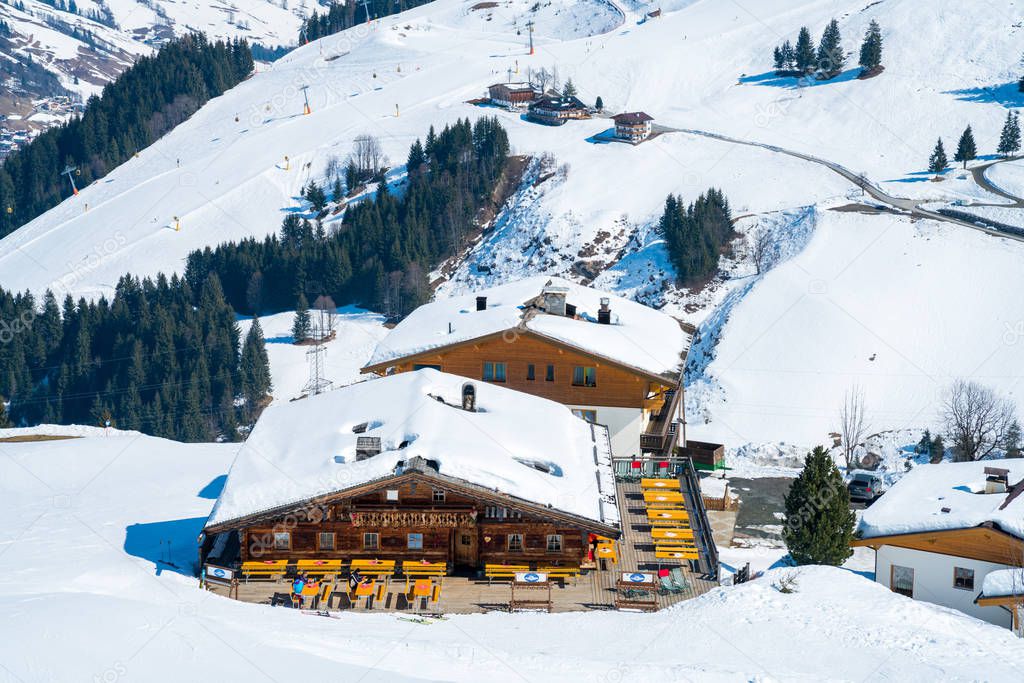 Beautiful ski resort right in the middle of the mountains in Austrian Alps. Amazing winter mountain view with small wooden houses and mountain slopes.