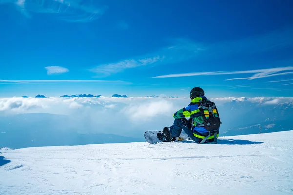 Jovem Snowboarder Sentado Topo Montanha Admirando Vista Sobre Nuvens Sentado — Fotografia de Stock