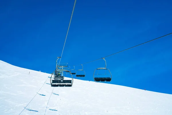 March 20, 2018. Austria. Ski lifts and cable cars going up the mountain bringing snowboarders to ski slopes. Ski resort.