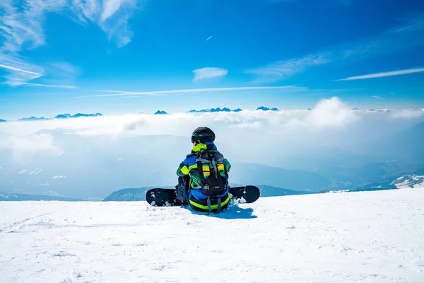 Jovem Snowboarder Sentado Topo Montanha Admirando Vista Sobre Nuvens Sentado — Fotografia de Stock
