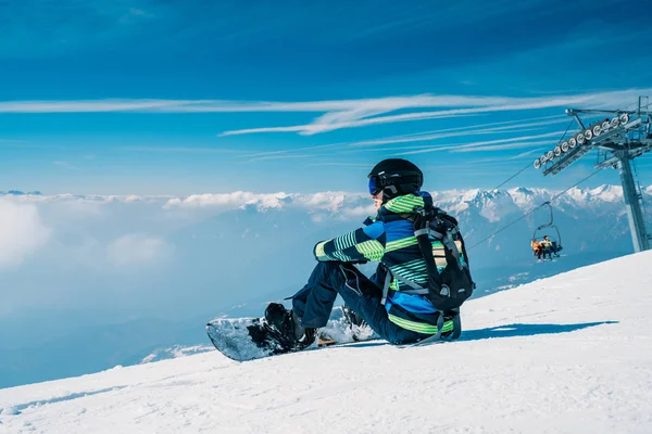 Jovem Snowboarder Sentado Topo Montanha Admirando Vista Sobre Nuvens Sentado — Fotografia de Stock