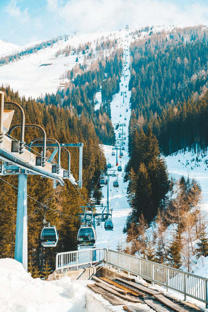 March 20, 2018. Austria. Ski lifts and cable cars going up the mountain bringing snowboarders to ski slopes. Ski resort.