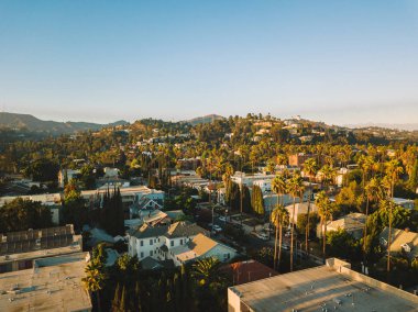 Palmiye ağaçları batımında Los Angeles'ta Hollywood yazısını ufukta ile Beverly Hills sokak.